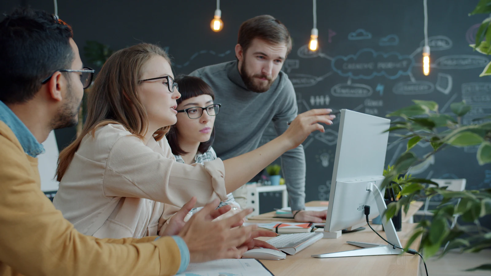 People discussing a shared piece of work around a monitor